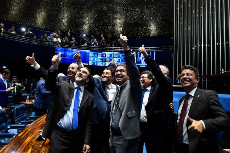 Os senadores Omar Aziz, Eduardo Braga e Randolfe Rodrigues, juntamente com o secretário extraordinário da reforma tributária do Ministério da Fazenda, Bernard Appy, comemoraram entusiasticamente a aprovação.